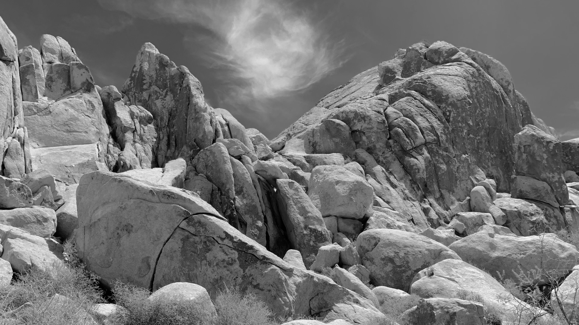 Field of weathered granite boulders under a bright high-contrast sky